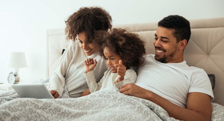 Family on laptop in bedroom